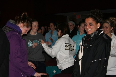 Students in the audience practice self-defense maneuvers. 