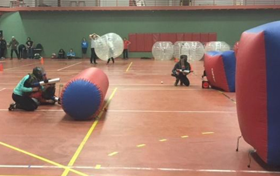 Madison O’Leary, Kayla Ali and Irene Grysiak take cover during a heated game of Bongo Ball in the Auxiliary Gym on Feb. 20.

